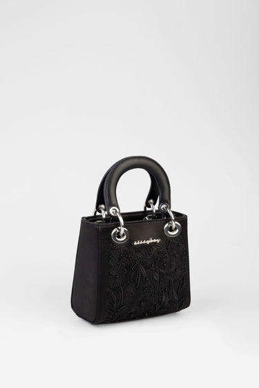 black mini bag with floral embroidery and silver ring handles.