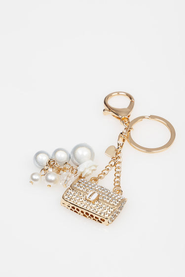 gold tone keychain with a rhinestone handbag pendant, pearl beads, a white rose, and crystal charms