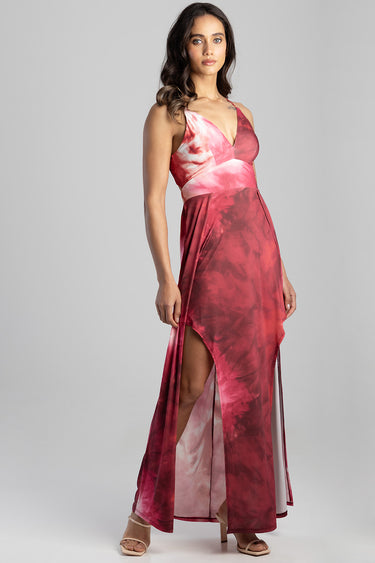 woman wearing a pink and red tie dye maxi dress with a plunging v neck and thin straps and a high side slit