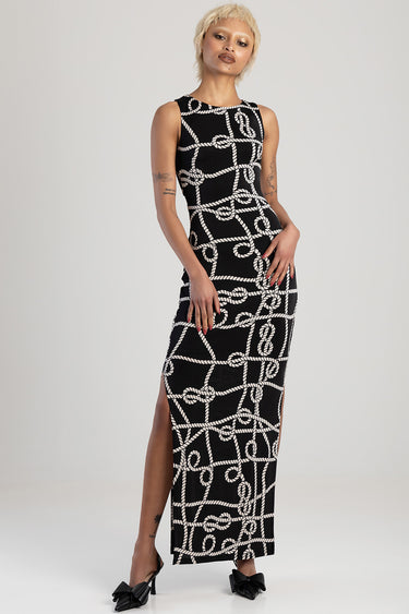 woman wearing a black sleeveless maxi dress with a white rope pattern, full length with a side slit, Blue Jean Traders.