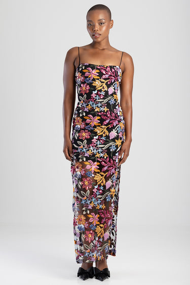 woman in a black floral maxi dress with thin spaghetti straps and a sheer lengthened skirt