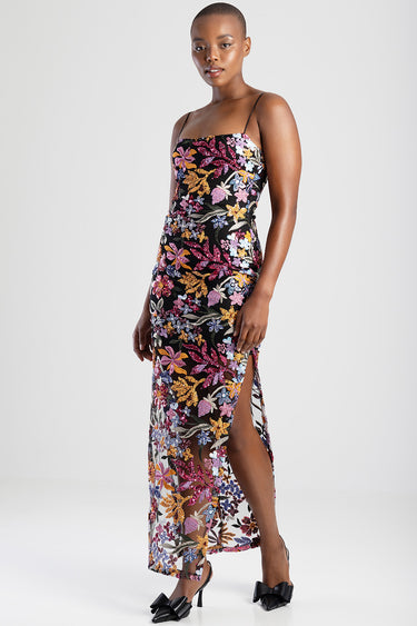 model wearing a black maxi dress with colourful floral embroidery, spaghetti straps and a side slit