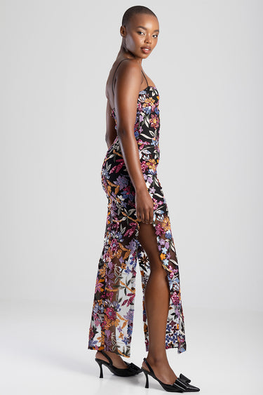 model wearing a black floral maxi dress with spaghetti straps, sheer overlay and side slit