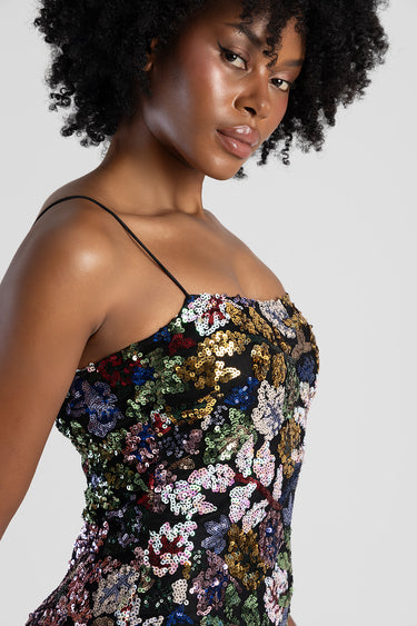 woman wearing a multicoloured sequin maxi dress with thin spaghetti straps close up of the upper body