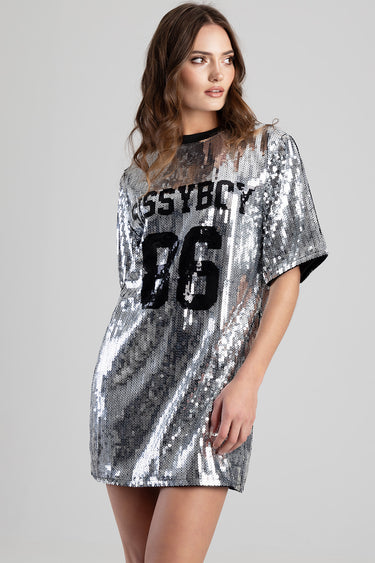 woman wearing a silver sequin t shirt dress with a black crew neck and bold black numbers on the front