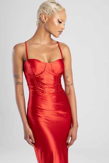 model wearing a red satin corset dress with thin straps and a fitted skirt