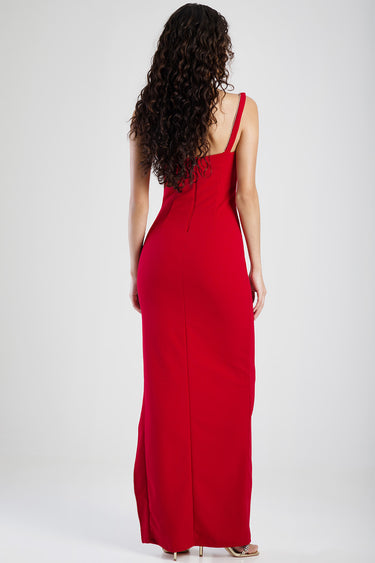 back view of a red maxi dress with a single thin shoulder strap, zipper at the back, on a model with long curly hair.