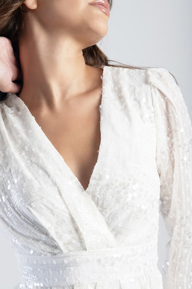 white sequin dress with a deep v neck and long puff sleeves, close up on the bodice