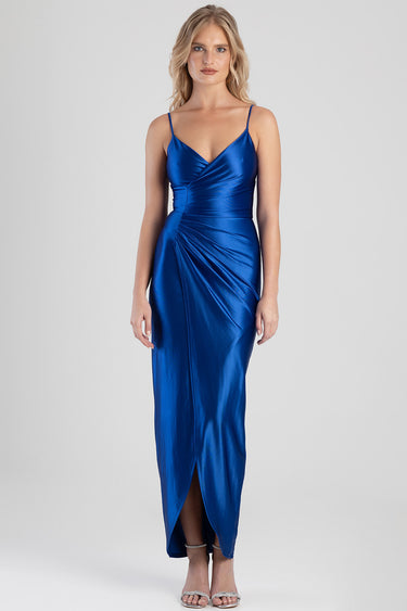 woman wearing a cobalt blue satin maxi dress with slender straps, wrapped bodice and draped skirt