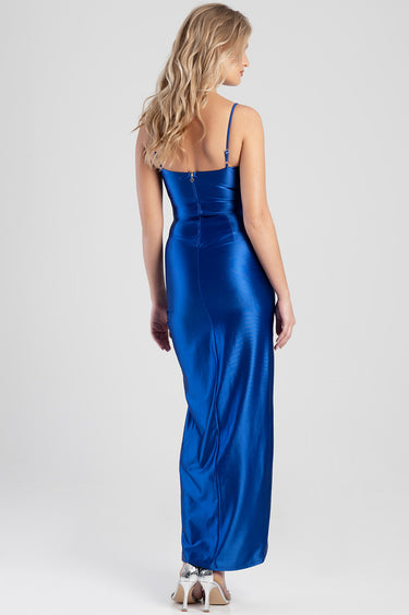 woman wearing a cobalt blue satin maxi dress with thin straps, back zipper, and silver heels
