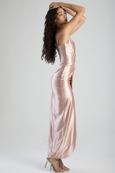 woman in blush satin maxi dress with spaghetti straps, side view, posing in gold sandals