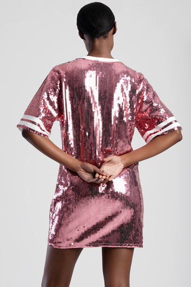 back view of a pink sequined t shirt dress with white striped short sleeves on a model