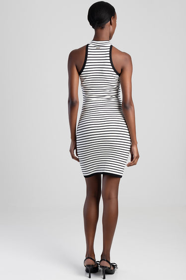 back view of a woman in a sleeveless striped knit dress with black trim at the neckline and armholes, knee length, wearing