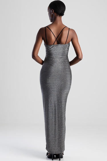 back view of a metallic silver glitter maxi dress with thin cross back straps floor length paired with black sandals