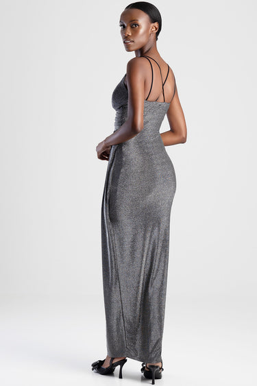 model wearing a shimmering gray maxi dress with crisscross back straps and black heeled sandals