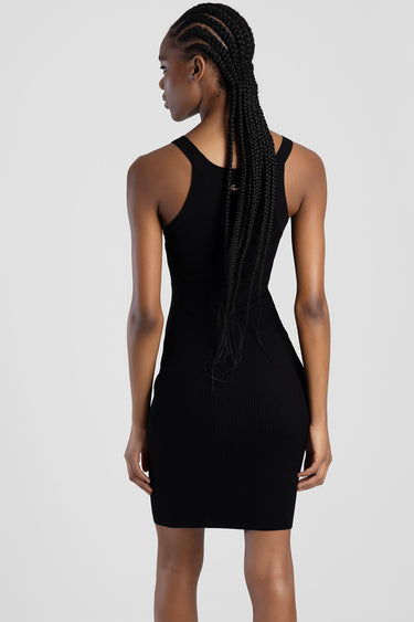 woman in a black ribbed knit sleeveless dress seen from the back with long braids down her back