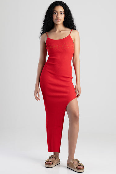 woman in a red ribbed knit dress with thin straps and a side slit, paired with gold platform sandals