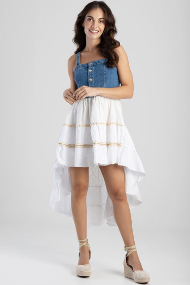woman wearing a sleeveless blue denim dress with a white tiered high low skirt and espadrille wedge sandals