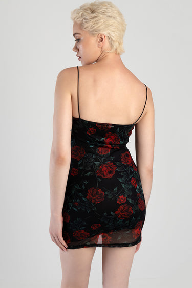 woman in a black floral mini dress with red roses, thin spaghetti straps, back view