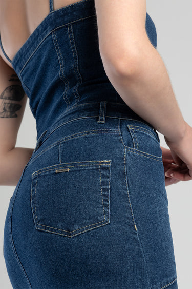 blue denim dress viewed from the side rear, showing the waist seam, back pocket, and contrast stitching