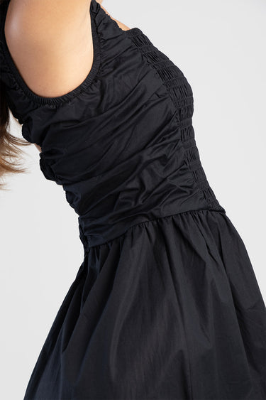 black dress with ruched sides and a full gathered skirt, sleeveless bodice