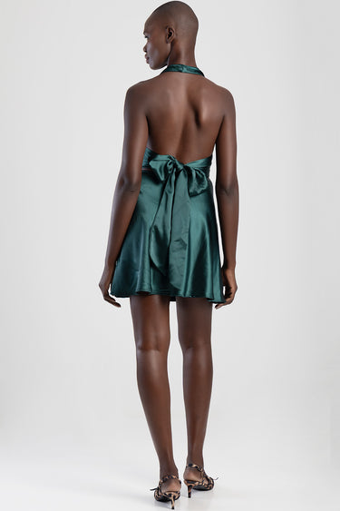 woman in emerald green satin halter neck mini dress tied with a large bow at the back