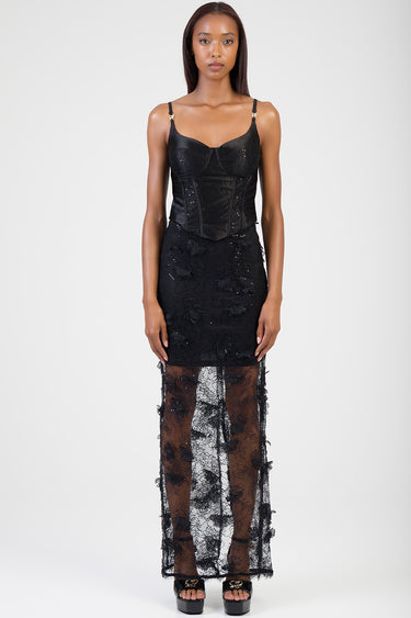 woman in a black lace maxi dress with a structured corset bodice and sheer lace overlay skirt, wearing black platform sandals