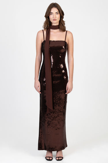 woman in a dark brown sequin maxi dress with thin straps and a brown scarf tied at the neck