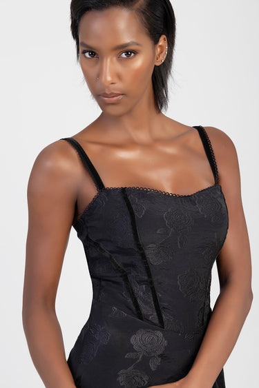 model wearing a black floral jacquard dress with spaghetti straps and lace trim