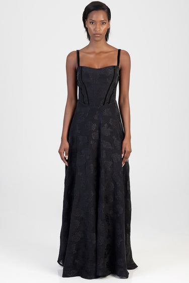 woman wearing a black floral lace maxi dress with slender straps and a fitted bodice