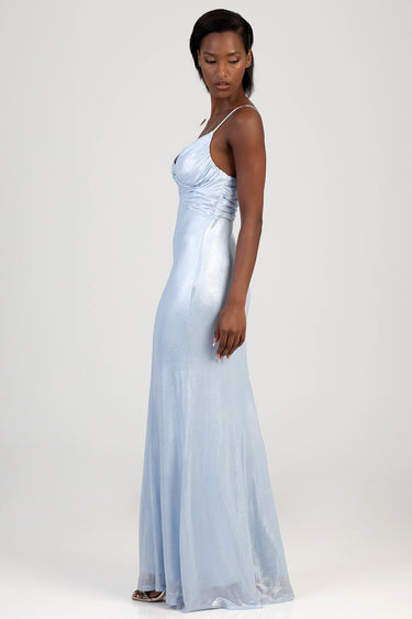 side profile of a woman wearing a light blue maxi dress with thin straps and a ruched bodice