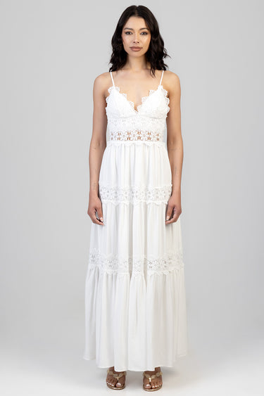 woman wearing a white lace maxi dress with spaghetti straps and a tiered skirt