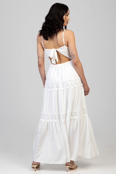 woman in a white maxi dress with lace tier panels, a back bow tie, and thin straps