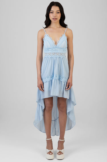 woman wearing light blue lace tiered midi dress with a high low hem and white platform sandals