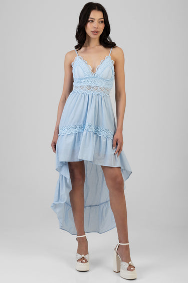 woman wearing a light blue lace bodice dress with spaghetti straps and a tiered high low skirt with lace trim paired with