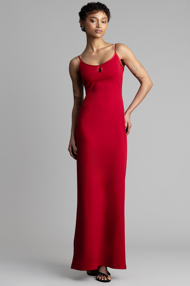 model wearing a red sleeveless maxi dress with thin straps and a small cutout at the neckline, full length against a grey