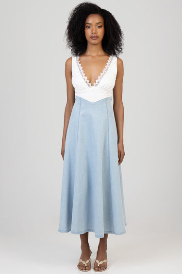 woman wearing a white lace trimmed deep v neck top paired with a light blue denim midi skirt