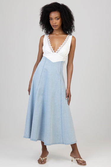 woman wearing white lace-trimmed deep V neck top and light blue denim midi dress with wide straps and sandals