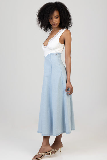 woman wearing a white lace trim top and light blue denim midi dress with a heart emblem and beige heeled sandals