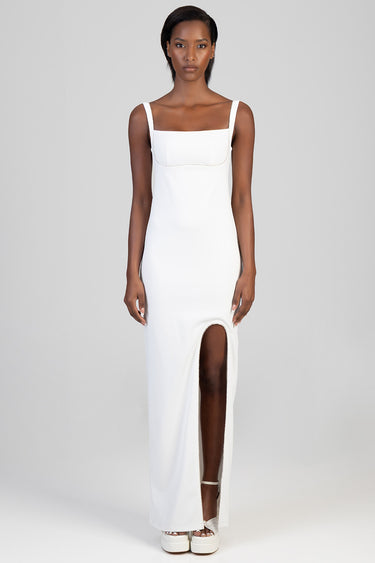 model wearing a white sleeveless maxi dress with a square neckline and a high slit at the front by Blue Jean Traders