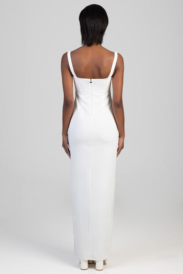 woman in a white sleeveless maxi dress with a back zipper, fitted waist, standing with her back to the camera