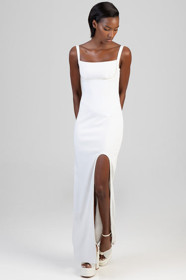 woman wearing a white maxi dress with wide straps, square neckline and a front leg slit