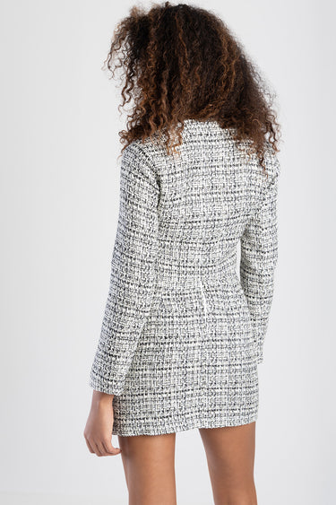 back view of a black and white tweed mini dress with long sleeves on a model