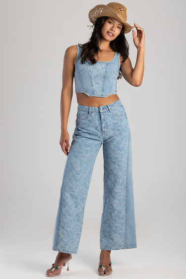 woman wearing light blue lace denim crop top and matching wide leg jeans with a straw cowboy hat