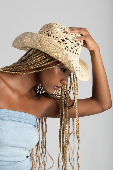 woman wearing a beige woven straw cowboy hat with long braided hair