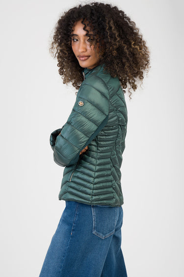 woman wearing a green puffer jacket with horizontal quilting and zip pockets, standing in profile
