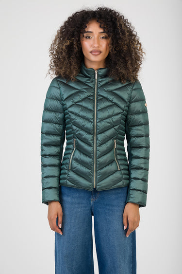 teal chevron quilted puffer jacket with high collar and silver zippers, two zip pockets, worn by a model in jeans