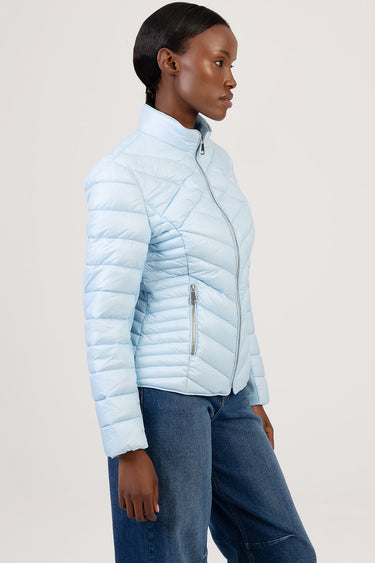 blue puffer jacket with a stand collar worn by a woman in profile; front zip closure, zip pockets, diagonal quilt