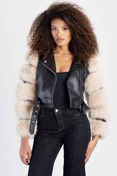 Blue Jean Traders black leather biker jacket with beige fur sleeves worn by a model in dark jeans and a black top