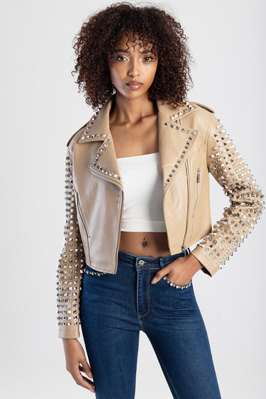 beige leather biker jacket with silver studs along shoulders and sleeves, zip details, over a white cropped top and dark